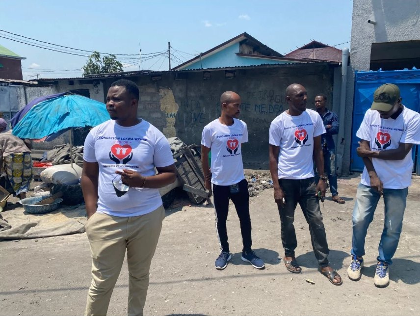 Membres de la FOLOK en t-shirts de la Fondation dans un quartier de Kinshasa